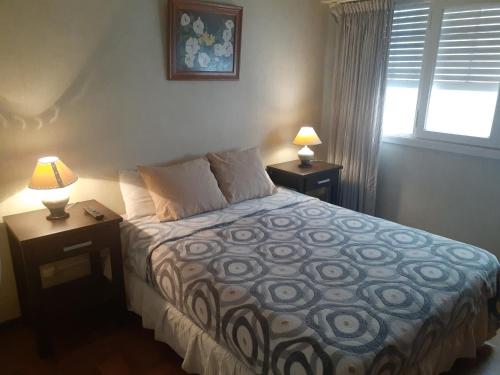 sypialnia z łóżkiem z 2 stolikami nocnymi i 2 lampami w obiekcie Departamento Mar del plata, solo grupo familiar w mieście Mar del Plata