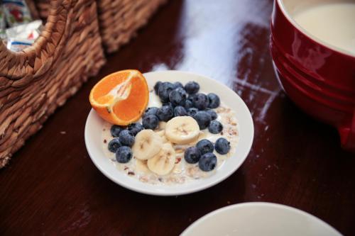 a white plate topped with fruit next to a cup of coffee at St Christopher's The Inn - London Bridge in London
