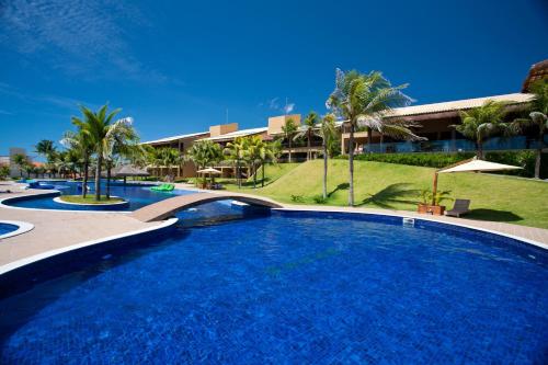 a large swimming pool in front of a resort at Carmel Charme Resort in Aquiraz