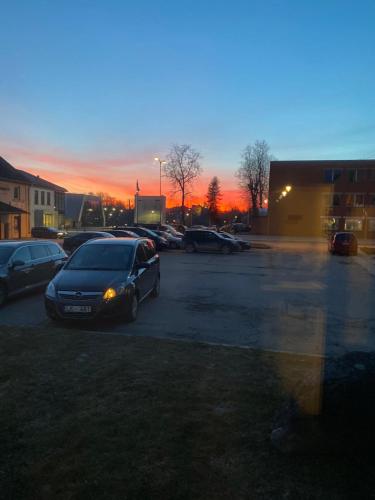 a parking lot with cars parked in front of a sunset at Guest house in Dobele city center- Pilsētas Māja in Dobele