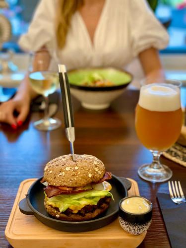 a sandwich on a plate on a table with a glass of beer at BURSZTYN - BERNSTEIN APARTMENTS in Dąbki