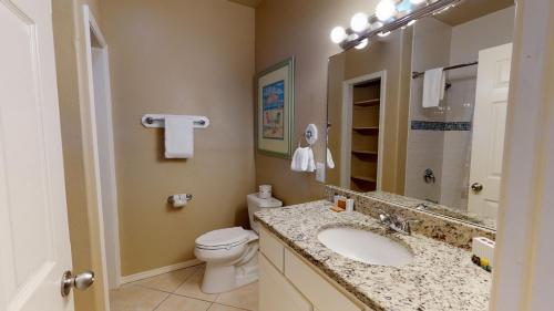 a bathroom with a sink and a toilet and a mirror at SFH201 Newly Renovated Ground Floor Townhome, Shared Pool, Near Beach in Port Aransas