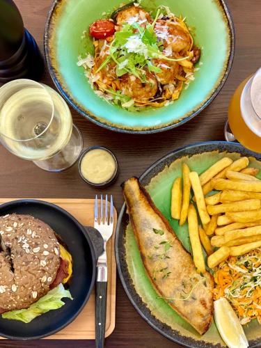a table with two plates of food and french fries at BURSZTYN - BERNSTEIN APARTMENTS in Dąbki