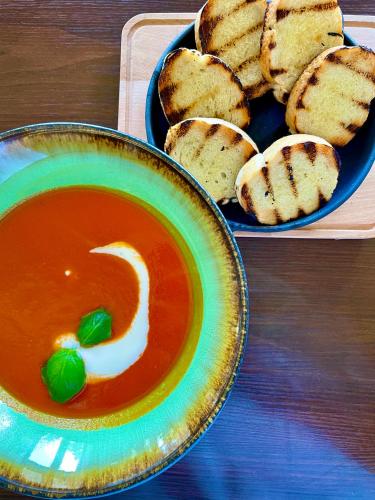a bowl of soup next to a plate of bread at BURSZTYN - BERNSTEIN APARTMENTS in Dąbki