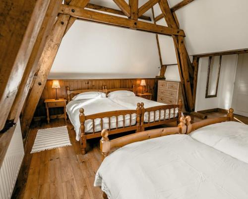 two beds in a room with wooden beams at Chateau de la Vigne in Concourson-sur-Layon