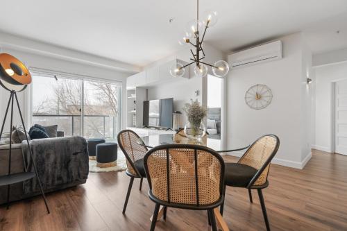 a dining room and living room with a table and chairs at INITIAL -CLASSE S- Centre-ville de Québec +stationnement in Quebec City