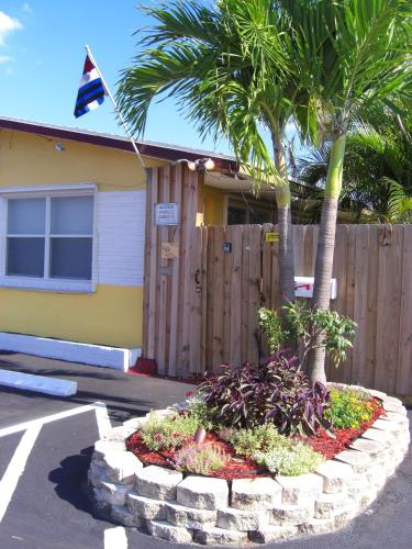a house with a palm tree and a flag at INN LEATHER GUEST HOUSE-GAY MALE ONLY in Fort Lauderdale