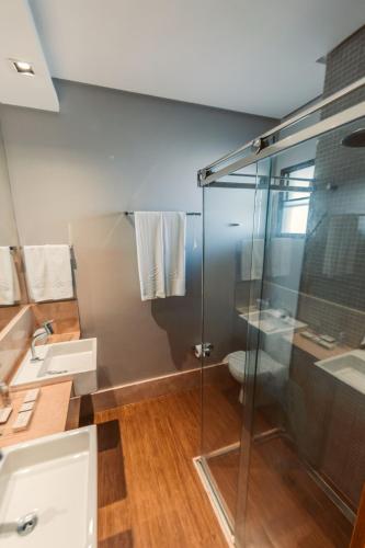 a bathroom with a glass shower and a toilet at Carmel Cumbuco Resort in Cumbuco