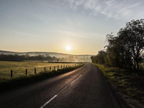an empty road with the sunset in the background at Greystead Institute in Hexham