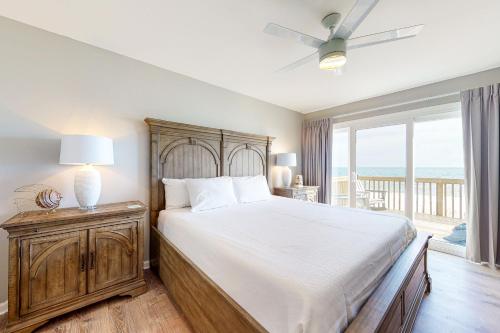 ein Schlafzimmer mit einem Bett und einem Balkon mit Meerblick in der Unterkunft Heavenly Days by Meyer Vacation Rentals in Fort Morgan