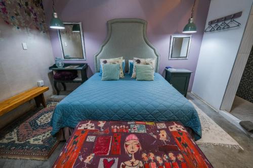 a bedroom with a bed with a blue comforter at Rose Acres Guest House in Parys