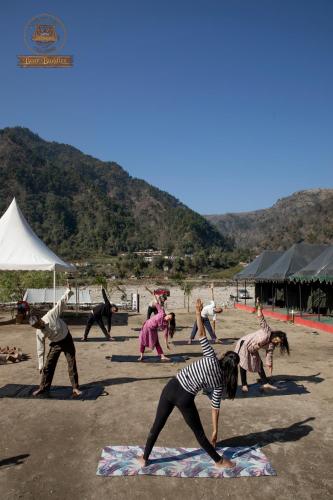 a group of people doing yoga on the beach at Riverside Swiss Camps "Adventure Bear Buddies" in Rishīkesh