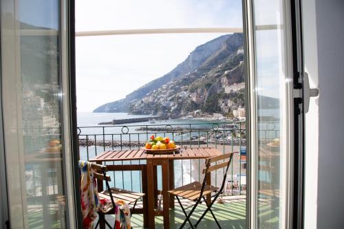 a table with a bowl of fruit on a balcony at Casa La Voce del Mare in Amalfi
