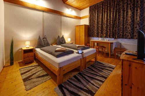 a bedroom with a bed and a desk and a table at Nádasdi Ház in Szekszárd