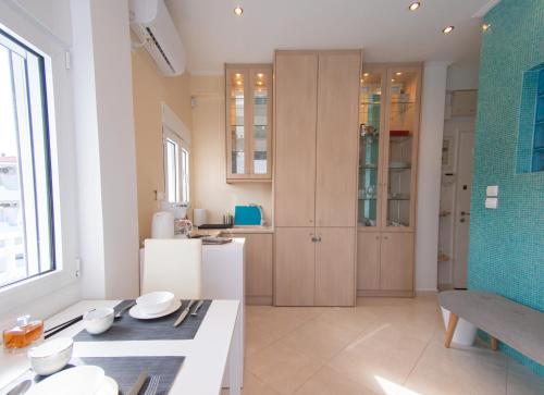 a kitchen with wooden cabinets and a table in a room at Lux Sea Studio - Porto Rafti in Porto Rafti