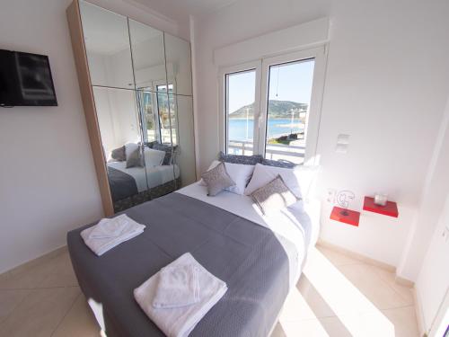 1 dormitorio con 1 cama grande y espejo grande en Lux Sea Studio - Porto Rafti, en Porto Rafti