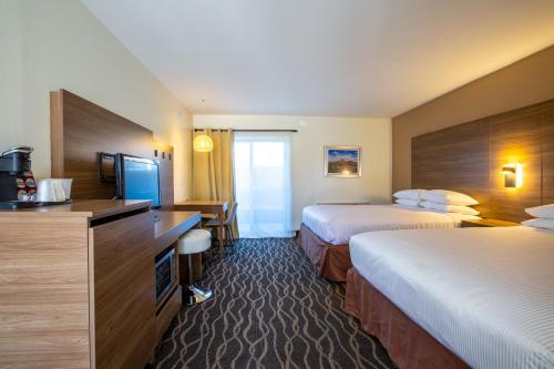 a hotel room with two beds and a television at Dreamcatcher Inn of Sedona in Sedona