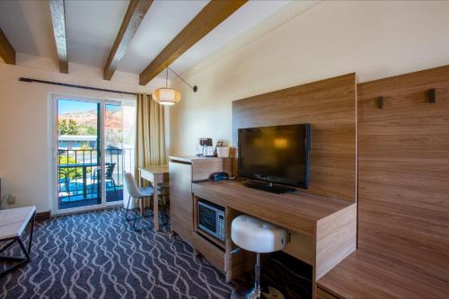 a room with a television and a desk with a chair at Dreamcatcher Inn of Sedona in Sedona