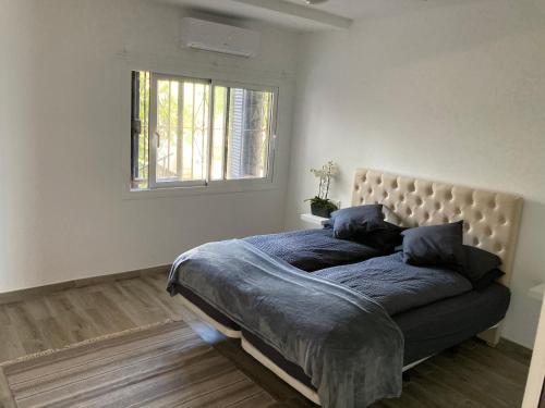 1 dormitorio con cama con sábanas azules y ventana en Beach Side Apartments Calahonda, en Sitio de Calahonda