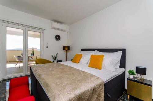 sypialnia z dużym łóżkiem z pomarańczowymi poduszkami w obiekcie Deluxe double room with sauna and pool w mieście Kaštela