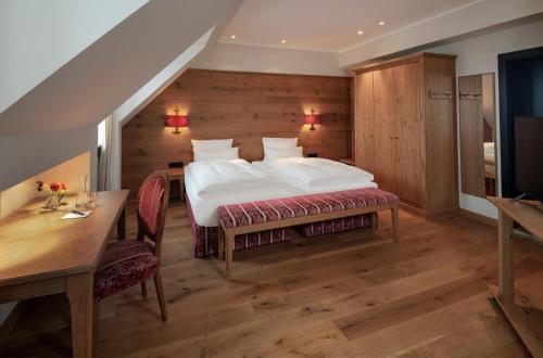 a bedroom with a bed and a table and chairs at Eden Hotel Wolff in Munich