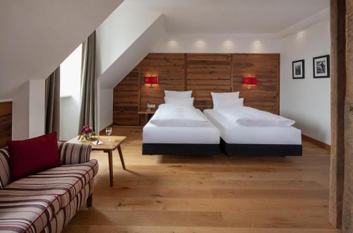 a hotel room with two beds and a couch at Eden Hotel Wolff in Munich