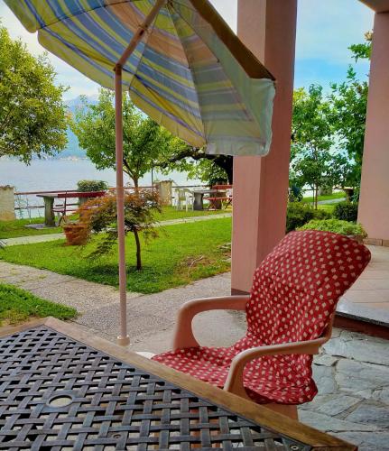 a chair sitting under an umbrella on a patio at Miralago Casa in Menaggio