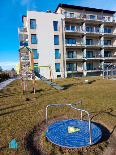 a playground in front of a apartment building at Pod Brzozami Apartamenty 5 Mórz in Ustronie Morskie