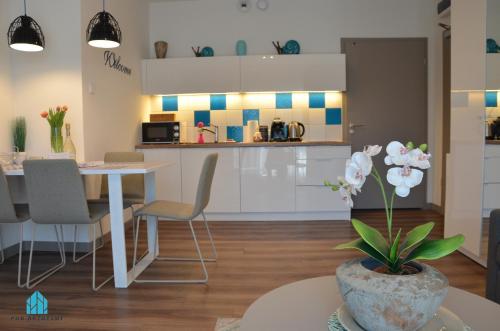 a kitchen and dining room with a table and chairs at Pod Brzozami Apartamenty 5 Mórz in Ustronie Morskie