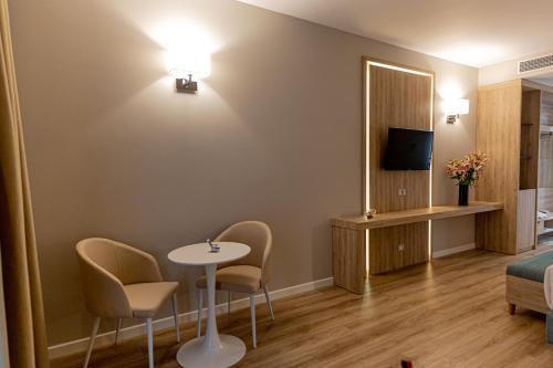 a hotel room with a table and chairs and a mirror at Regina Blu in Vlorë