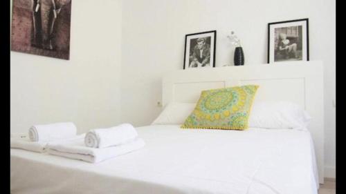 Una cama blanca con dos toallas encima. en El Rincón de Sonia, en Rincón de la Victoria