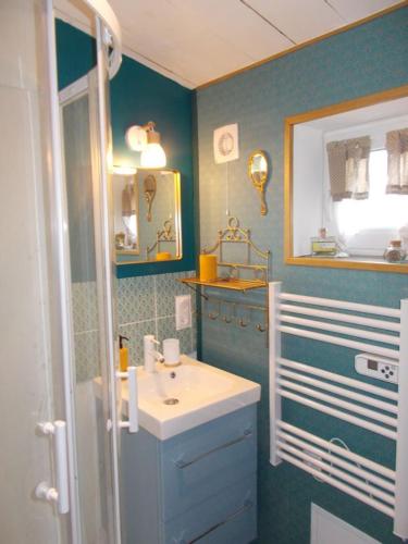 a blue bathroom with a sink and a mirror at Les deux moulins in Saint-Alban