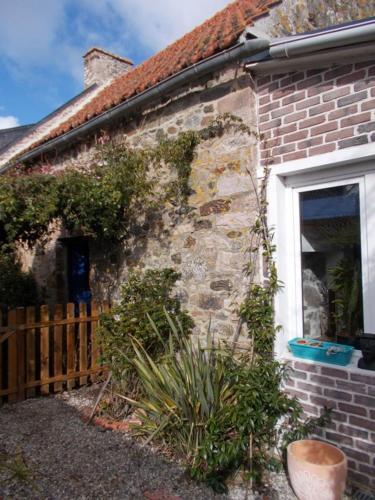 une maison en briques avec une fenêtre et une clôture dans l'établissement Les deux moulins, à Saint-Alban
