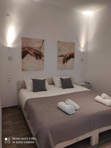a bedroom with a bed and two paintings on the wall at Ch apartment's Mykonos in Ornos