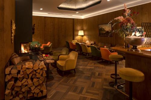 a restaurant with chairs and a bar with a pile of wood at Eden Hotel Wolff in Munich