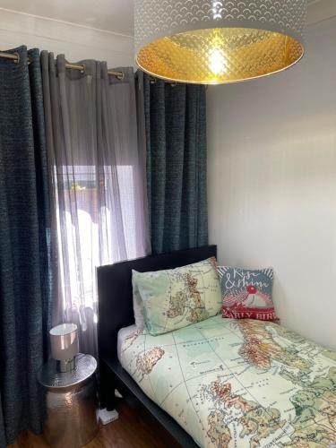 a bedroom with a bed and a chandelier at The Annexe @The Oaks in Golden Valley