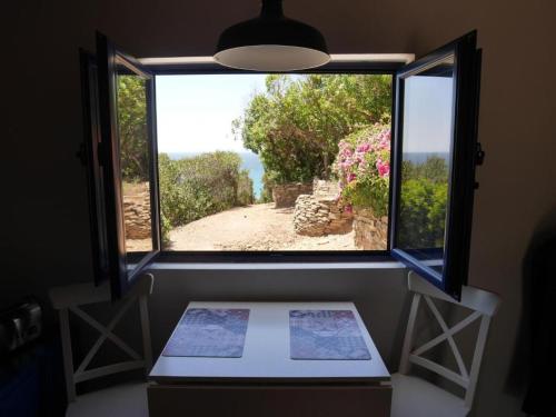 a window in a room with a view of a garden at Herdade AMÁLIA RODRIGUES in Zambujeira do Mar
