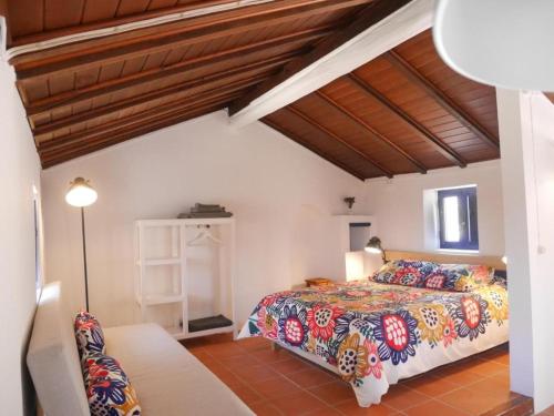 um quarto com uma cama e um tecto de madeira em Herdade AMÁLIA RODRIGUES na Zambujeira do Mar
