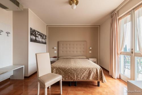 シルミオーネにあるAlbergo Bagnerのベッドルーム1室(ベッド1台、椅子付)