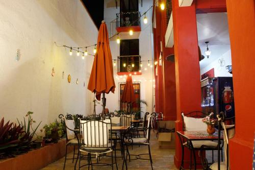 a dining room with a table and chairs and umbrellas at Posada Don Mario in Oaxaca City