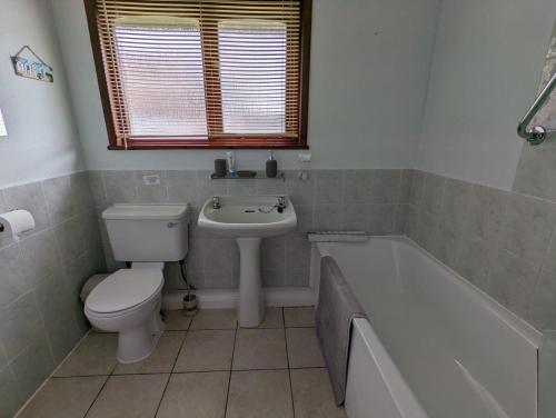 een badkamer met een toilet, een bad en een wastafel bij 55, Hengar Manor Estate in Saint Tudy