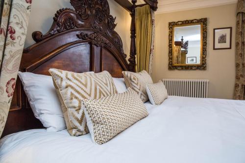 a bedroom with a large bed with white sheets and pillows at Goldsborough Hall in Knaresborough