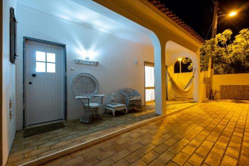a patio with a door and a table and chairs at Villa O Canto da Parra - Hot Jacuzzi - Swimming Pool - WIFI - BY BEDZY in Galé