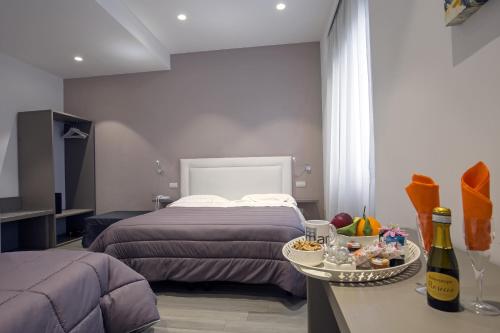 a bedroom with a bed and a table with a tray of food at Hotel Bruman Salerno in Salerno