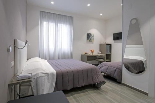 Habitación de hotel con cama y espejo en Hotel Bruman Salerno, en Salerno