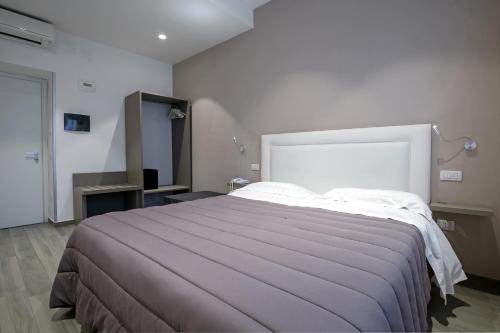 a bedroom with a large bed in a room at Hotel Bruman Salerno in Salerno
