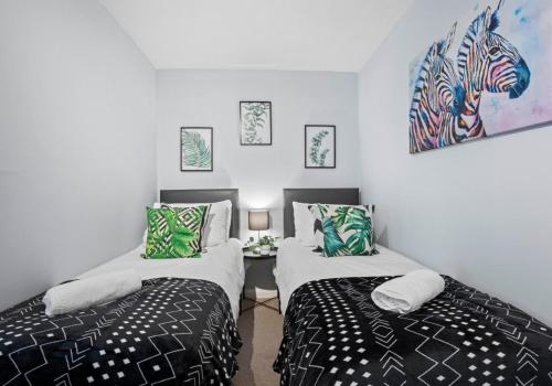- une chambre avec 2 lits et un tableau mural dans l'établissement Hampton Hideaway By My Getaways, à Brighton et Hove
