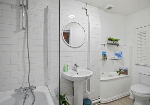 Baño blanco con lavabo y aseo en Hampton Hideaway By My Getaways en Brighton & Hove