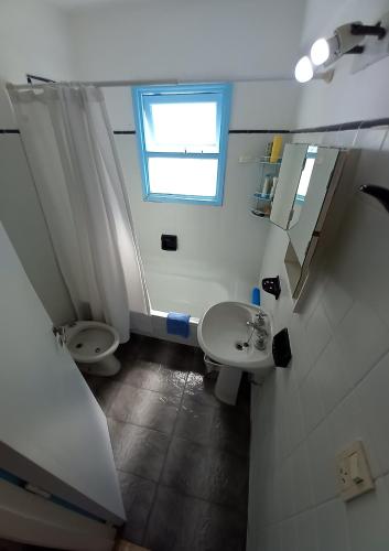 a bathroom with a sink and a toilet and a window at DESCANSO IDEAL II CABO CORRIENTES in Mar del Plata