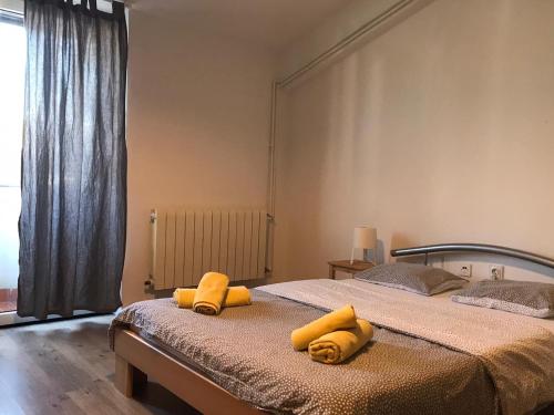 a bedroom with two beds with yellow towels on them at Apartmani Vacanza in Zagreb